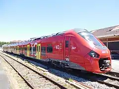 Rame aux couleurs LiO quittant la gare d'Albi-Ville. Le logo Alstom en métal est visible sur la calandre.