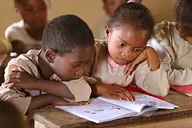 Deux élèves malgaches lisent le même livre