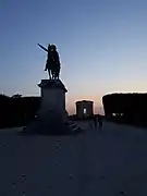 Vue du château d'eau et la statue avec le soleil couchant.