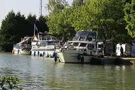 Photographie du port de plaisance sur le canal depuis la berge opposée.