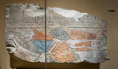 Fragment d'un relief représentant une pile d'offrandes et une partie d'une liste d'offrandes.