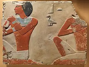 Fragment d'un relief représentant deux fonctionnaires ou fils de Dagi en position agenouillée.