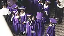 vue en plongée sur un groupe  d'une dizaine de jeunes gens d'une dizaine d'années en toge violette