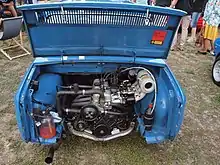 Le capot d'une voiture bleue ouvert sur un moteur en position arrière.