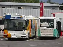 Photographie en couleurs du bus utilisé comme agence itinérante et du minibus utilisé pour la promotion du nouveau Plan de Déplacements Urbains de Chambéry, ici au dépôt en septembre 2016.
