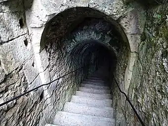 Photographie en couleurs d'un escalier s'enfonçant sous terre.