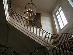 Escalier d’honneur à volées droites, garde-corps avec main-courante et plafonnier.