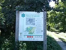 Photographie d'un panneau signalant l'entrée dans la réserve naturelle nationale des marais de Bruges.