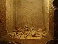 Reconstitution d'une tombe avec restes humains et poteries dans le département préhistorique.