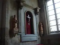 Retable classique d'une des chapelles latérales (en provenance de l'église Sainte-Cécile). Le retable est incomplet, par l'absence des colonnes ; les chapiteaux des colonnes qui subsistent sont d'ordre corinthien. Le retable possède une niche, avec une croix dans son centre.