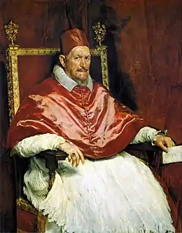 Dans des nuances de rouges, avec quelques touches blanches, le Pape, le regard sévère et inquiet assis sur son trône