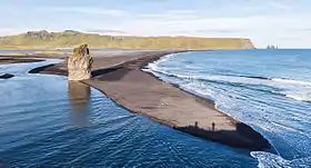 La Reynisfjall vue depuis Dyrhólaey à l'ouest avec l'Arnardrangur au premier plan et les Reynisdrangar à droite.