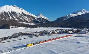 Un Regio Express (St-Moritz-Coire) des RhB sur la Ligne de l'Albula entre Celerina et Samedan avec la H27 et l'Inn.