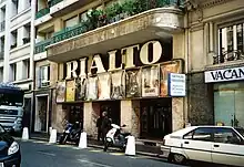Vue de jour d'un petit cinéma avec son enseigne de lettres majuscules géantes « RIALTO » éteinte.