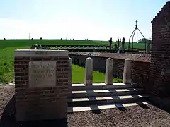 Le cimetière militaire britannique est derrière le cimetière communal, avec un accès sur la gauche de celui-ci.
