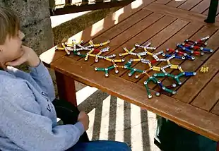 enfant jouant avec une structure moléculaire