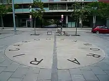 Photographie du sol d'une place de Barcelone avec un grand cercle et le nom de Ricardo Zamora sur le bord de celui-ci.