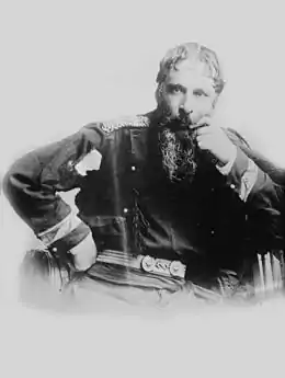 photographie noir et blanc : un homme barbu en uniforme, assis