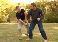 Richard Douieb (en tee-shirt noir) faisant une démonstration d'une technique de défense de krav-maga contre une attaque au couteau.