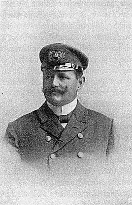 Portrait en noir et blanc d'un homme à moustache en uniforme de la marine.
