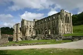 Photographie des ruines d'une église gothique de grandes dimensions, dont les murs sont debout jusqu'à la voûte.