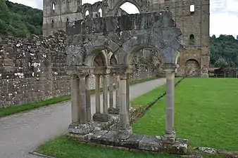 Photographie d'arches romanes et d'un bâtiment en arrière-plan.