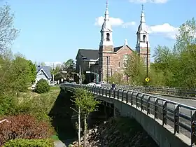 Pont Rigaud-De Cavagnal, à l'arrière-plan l'église Sainte-Madeleine de Rigaud