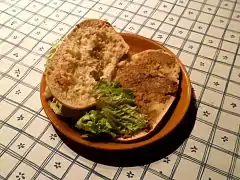Photographie en couleurs de tranches de pain tartinées de rillettes de Tours dans une assiette.