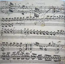 Cinq lignes d'écriture musicale serrée, manuscrite à l'encre noire