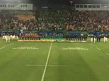 vue depuis la tribune opposée du podium olympiques, les joueuses étant toutes tournées vers la droite.