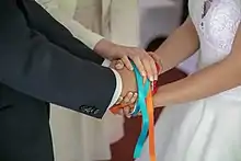Les rubans sont liés aux mains des mariés