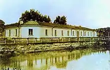 Photographie de maisons d'un étage au bord d'un canal ou d'un fossé.