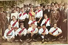 photo de groupe d'hommes, au centre, sur trois rangs, des hommes en maillot rouge et blanc