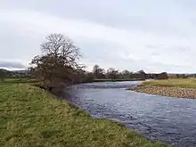 Photographie couleur montrant une rivière coulant dans un paysage de plaine