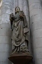 Photographie en couleurs d'une statue nichée au creux d'un pilier d'église.