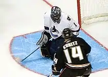 Chris Kunitz (maillot noir) effectue un tir contre Roberto Luongo (maillot blanc)