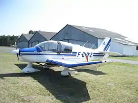 Robin DR-400 de l'aéroclub d’Andernos sur l'aire de stationnement (en arrière-plan les hangars)