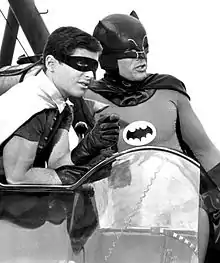 photo en noir et blanc de Batman et de Robin dans ce qui semble être un véhicule