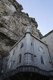 La chapelle adossée à la falaise et la basilique