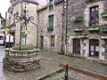 Le vieux puits et les maisons avoisinantes.