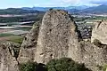 Vue rapprochée du poudingue des Pénitents avec la vallée de la Durance en arrière-plan