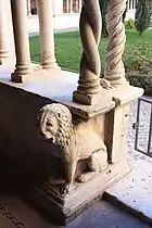 Un lion en ronde-bosse à la base du cloître.