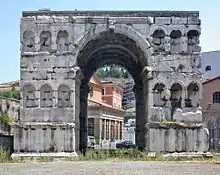 Photographie en couleurs d'un monument antique en forme d'arc de triomphe.