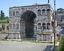 Photographie en couleurs d'un monument antique semblable à un arc de triomphe.