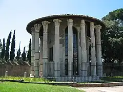 Photographie en couleurs d'un bâtiment circulaire circonscrit par une colonnade.