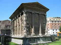 Photographie en couleurs d'un édifice antique avec des colonnes et un fronton triangulaire.