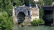 Photographie en couleurs de l'arche isolée d'un pont antique.