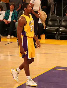 Un joueur marchant arborant le maillot jaune et bleu des Lakers portant le numéro 37