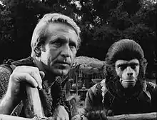 Deux hommes dont un déguisé en chimpanzé.