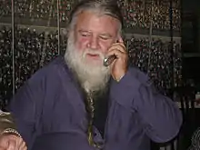 Photo en couleur d'un homme âgé avec cheveux poivre et sel et barbe. blanche